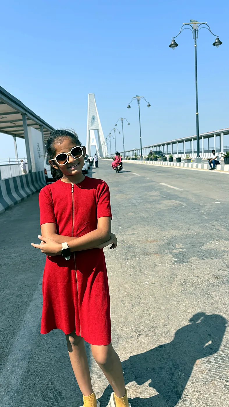 Nishtha in a red dress on a bridge