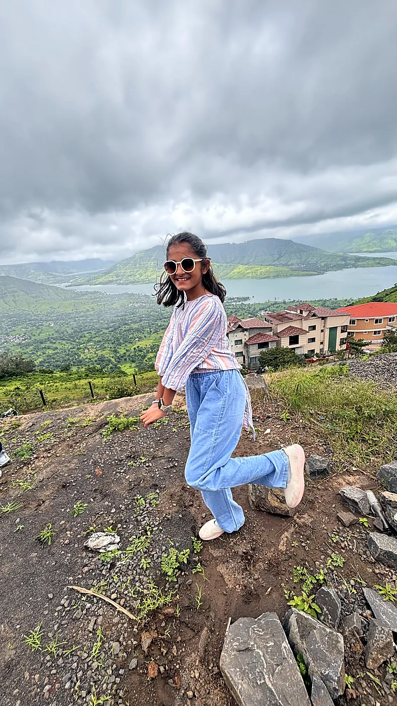 Nishtha on a hilltop under a cloudy sky