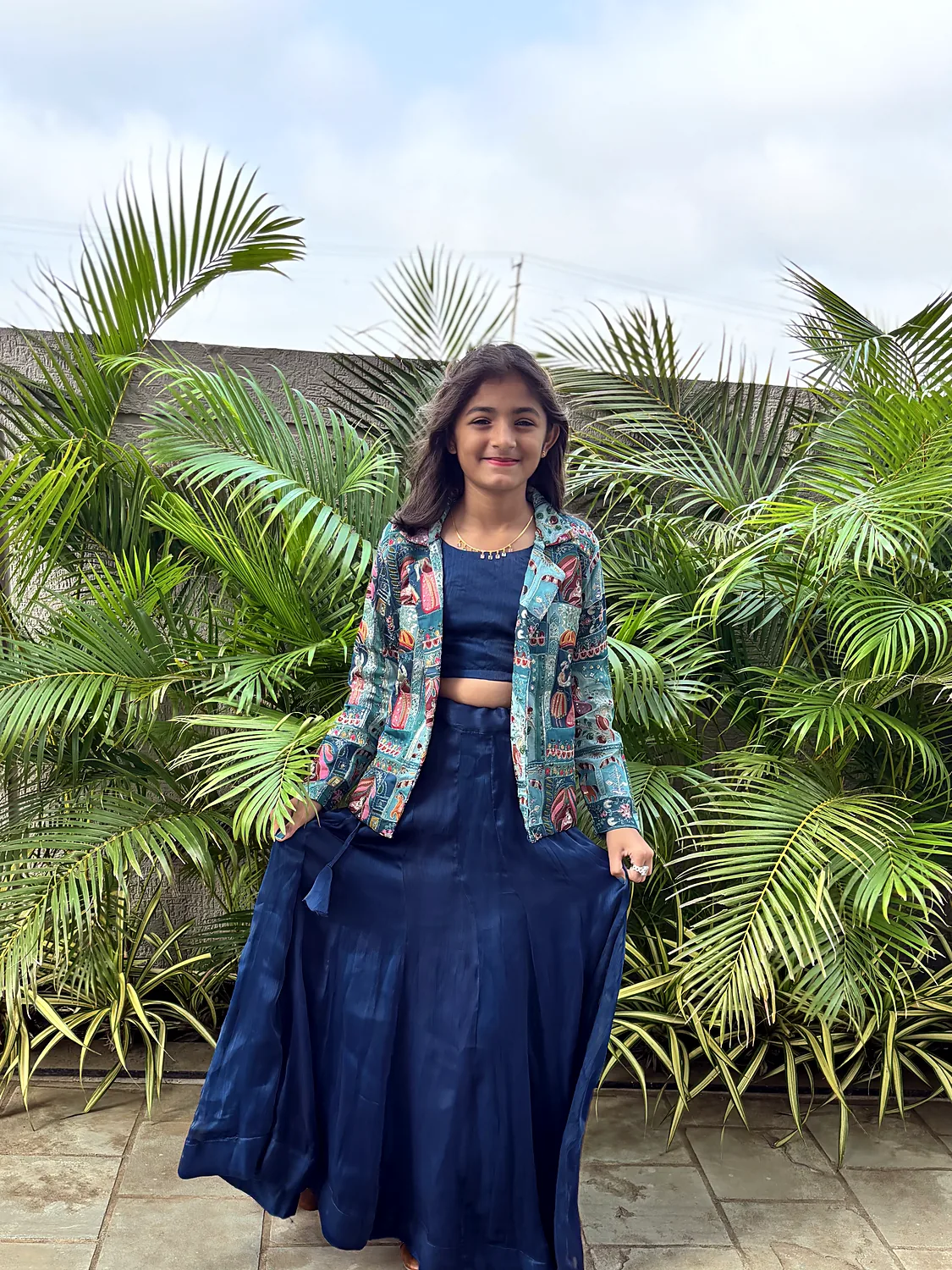 Nishtha in a navy lehenga in front of palms