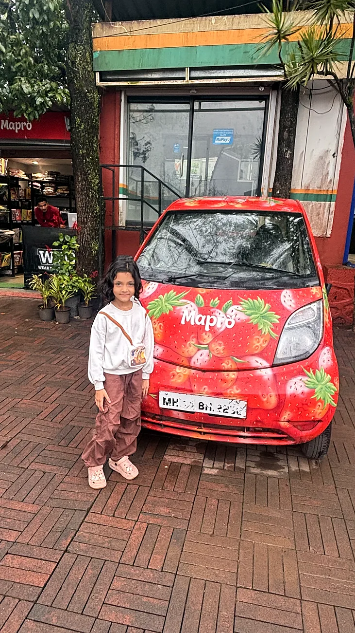 Nityaah beside a strawberry-painted car