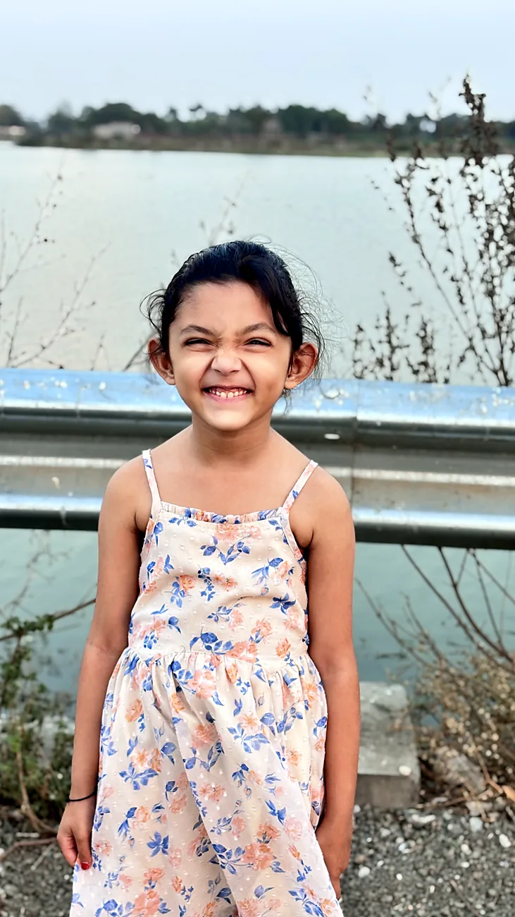 Nityaah in a floral dress by a lake