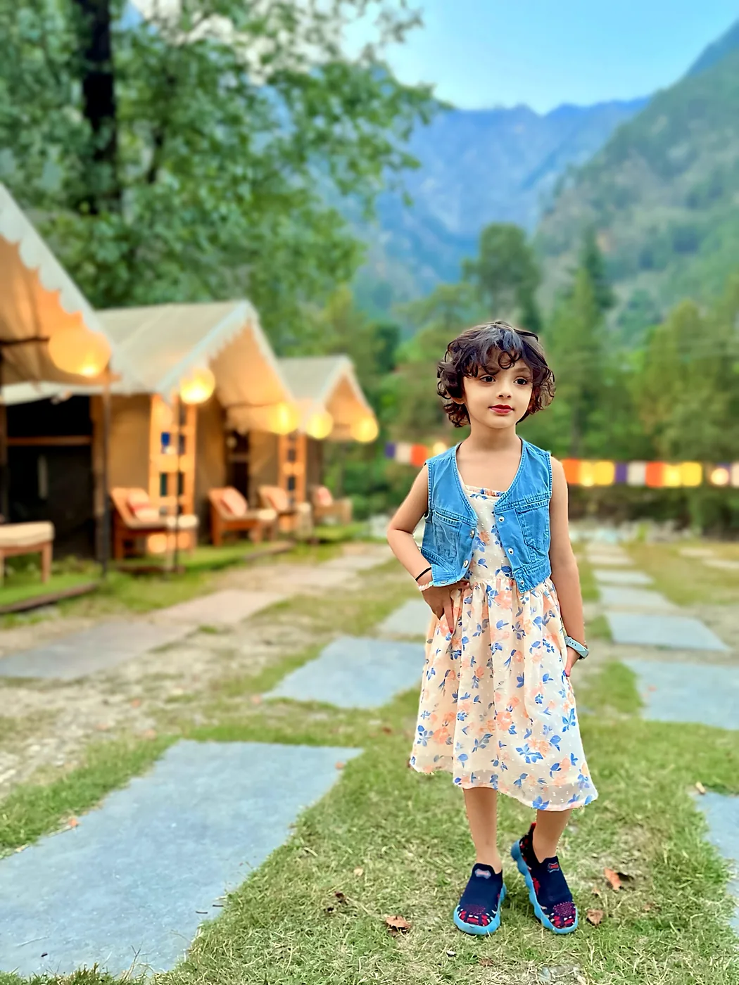 Nityaah in front of mountain cottages