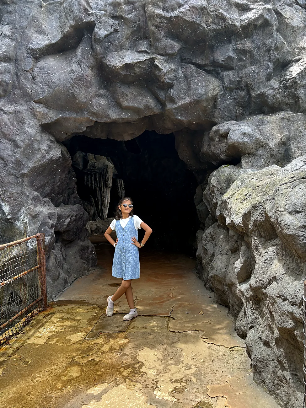 Nityaah standing at the mouth of a rock cave
