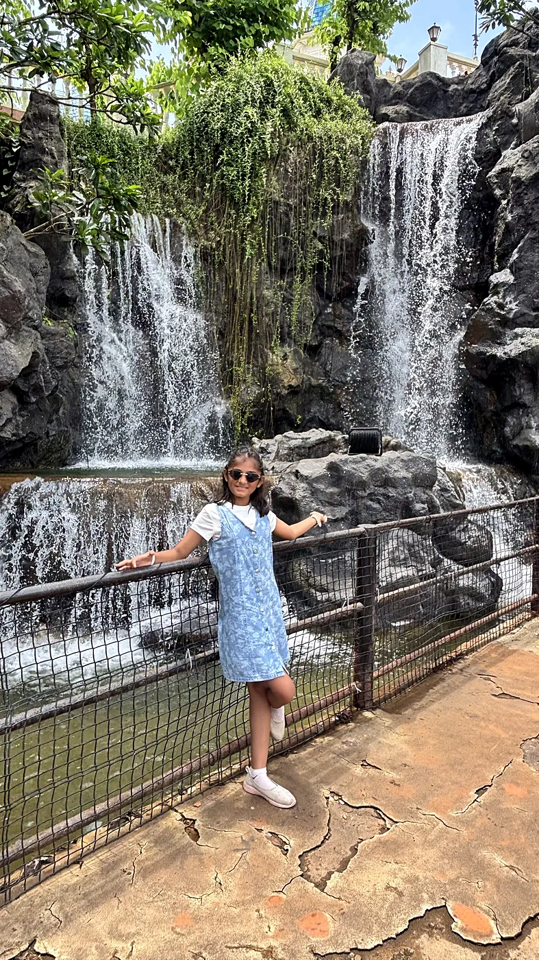 Nityaah beside a waterfall