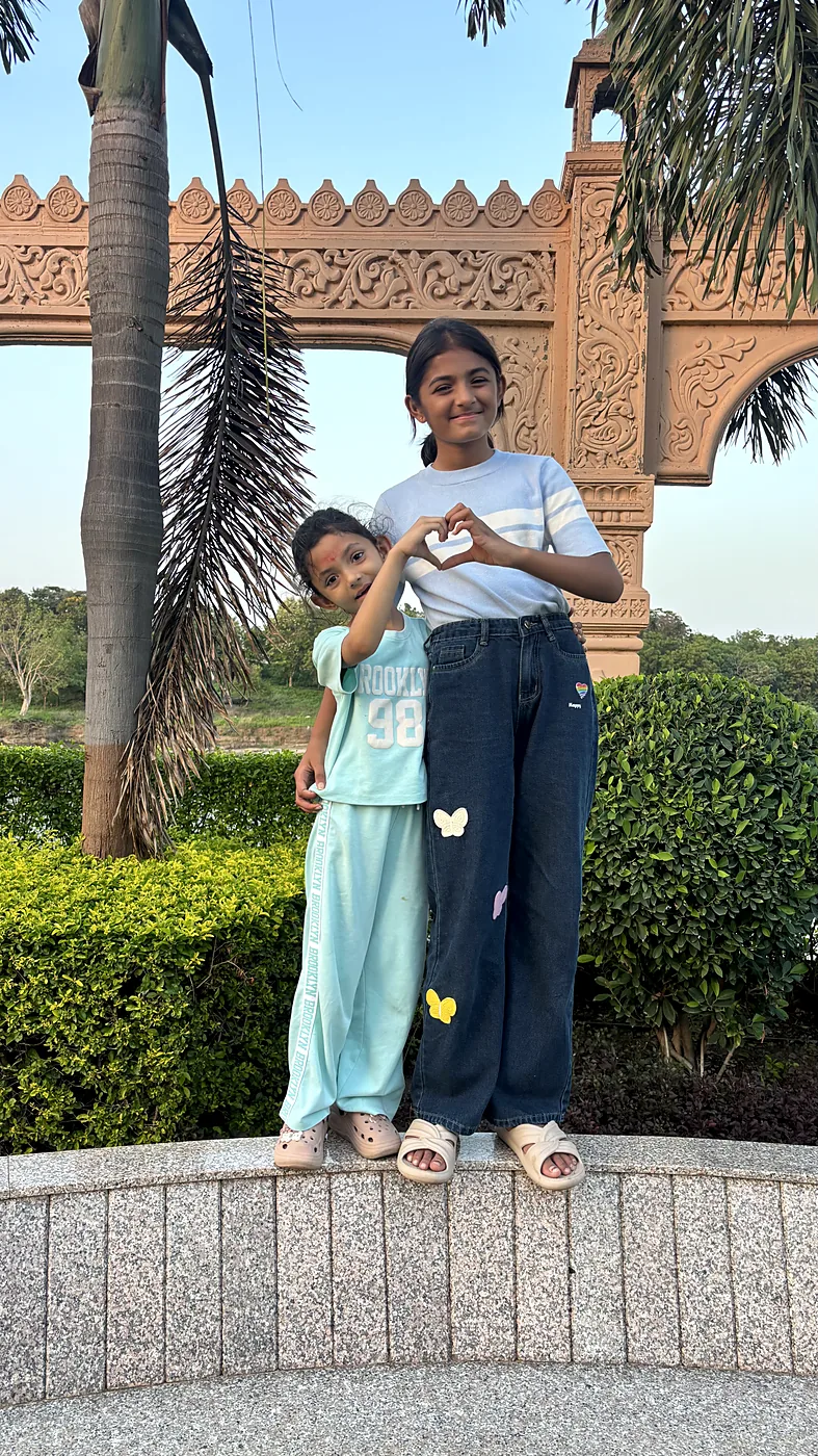 Nishtha and Nityaah making a heart shape with their hands
