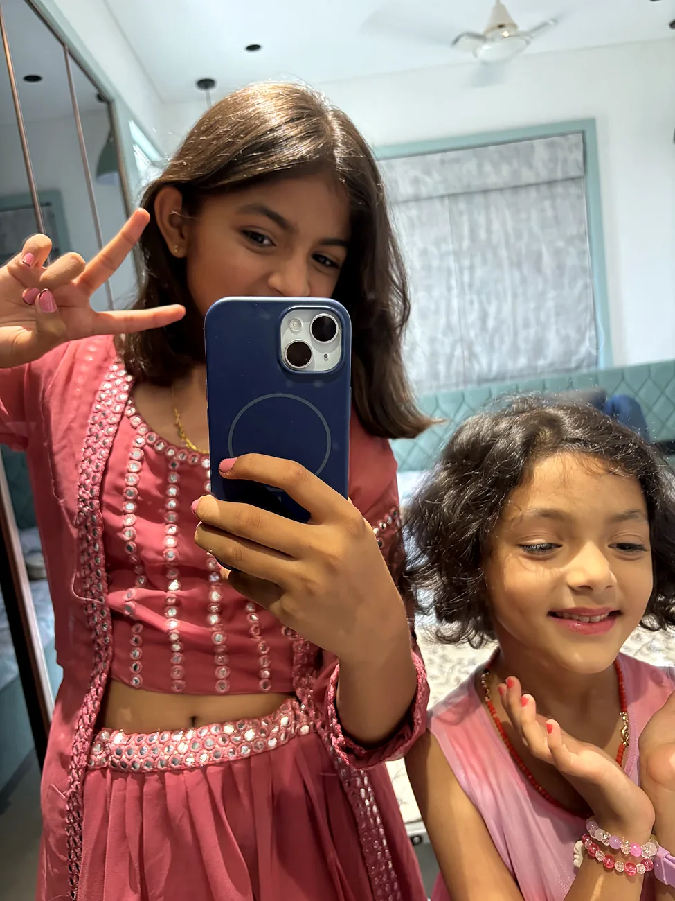 Mirror selfie of the two sisters in festival clothes